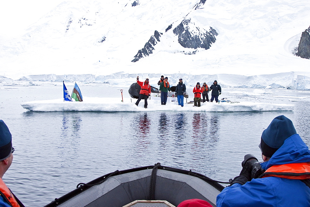 Guests from the Lindblad Expedition ship National Geographic Explorer enjoy a hot asado sandwich prepared by staff at BBQ on an ice floe near Adelaide Island, Antarctica