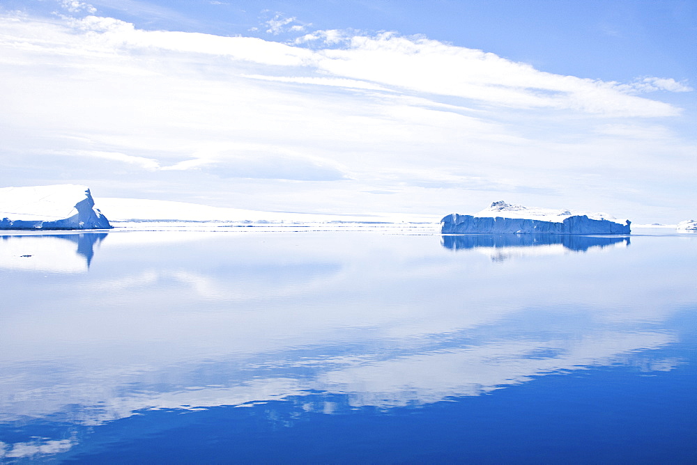 Flat calm conditions in Crystal Sound, south of the Antarctic Circle, Antarctica, Southern Ocean. MORE INFO This area is full of flat first year sea ice, well developed icebergs, with many open leads.