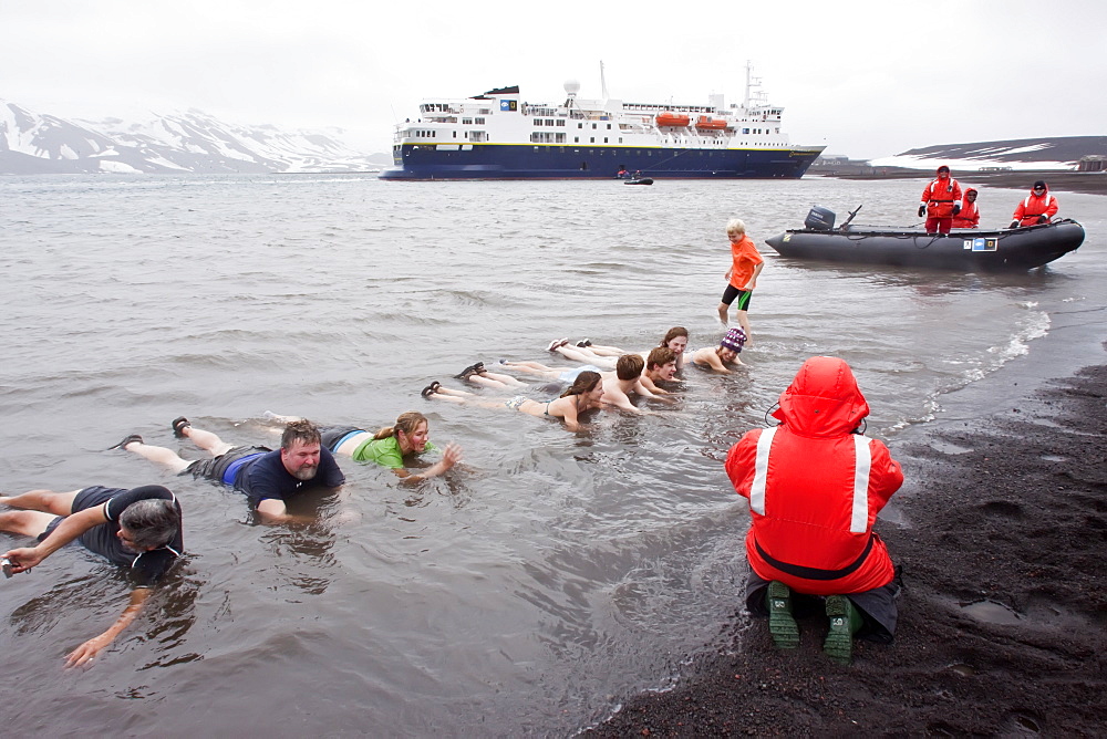 Guests from the Lindblad Expedition ship National Geographic Explorer lay in the relatively warm waters of the caldera at Deception Island, South Shetland Islands, Antarctica