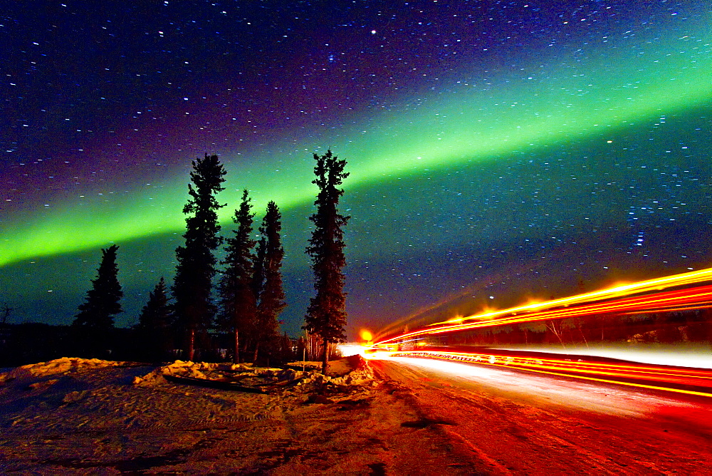 Aurora Borealis (Northern (Polar) Lights) with truckers lights on the ice road outside Yellowknife, Northwest Territories, Canada