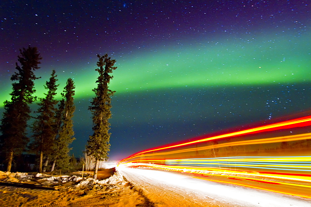 Aurora Borealis (Northern (Polar) Lights) with truckers lights on the ice road outside Yellowknife, Northwest Territories, Canada