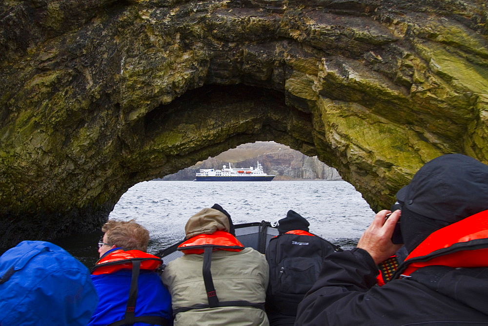 The Lindblad Expeditions ship National Geographic Explorer along the Fuglefjellet cliffs (411m) on Bear Island (Bjornoya) in the Svalbard Archipelago, Norway