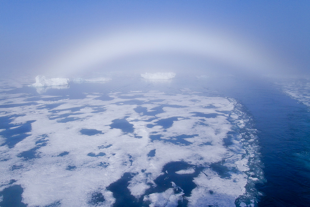 Fog and a fog bow surround the Lindblad Expeditions ship National Geographic Explorer in Palanderbutka, Nordaustlandet, in the Svalbard Archipelago, Norway