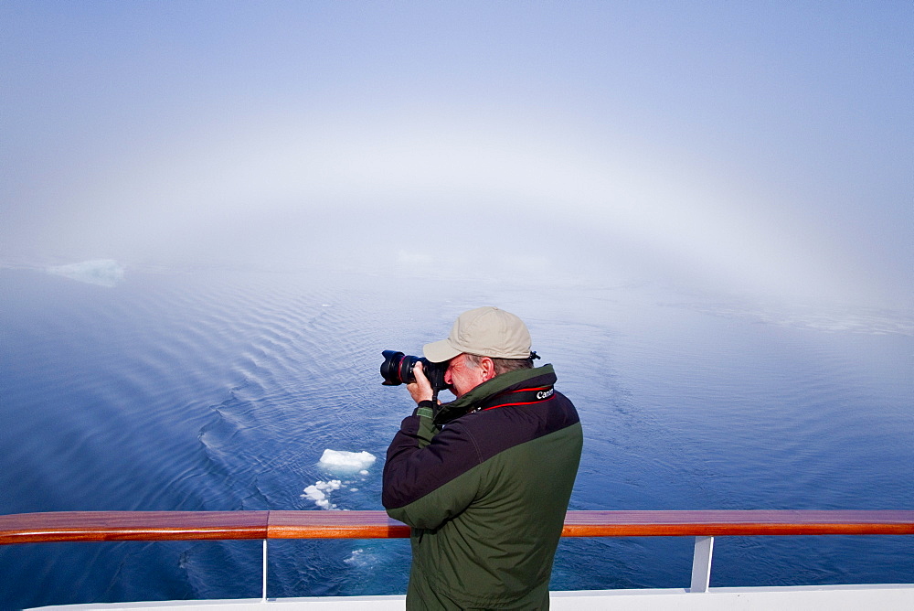 Fog and a fog bow surround the Lindblad Expeditions ship National Geographic Explorer in Palanderbutka, Nordaustlandet, in the Svalbard Archipelago, Norway