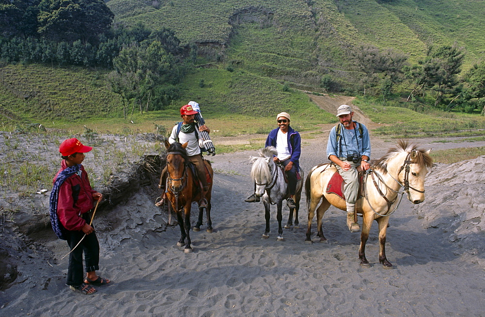 Moving camera crew and equipment on horse back to filmm Mount Bromo.  Java, Indonesia