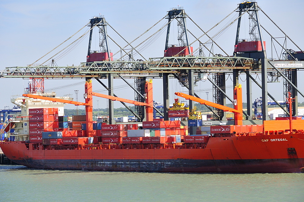 Container being loaded onto container ship by loading derrick at Felixstowe Docks, Suffolk, England, United Kingdom, Europe