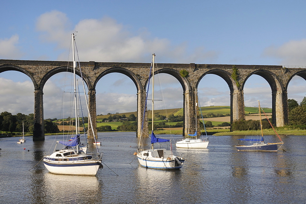 Sailing yachts moored in the River Lynher at high tide below St. Germans railway viaduct, Cornwall, England, United Kingdom, Europe