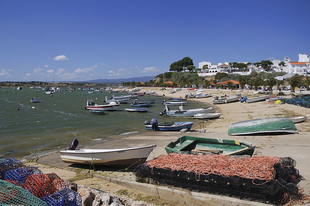 Lobster pots on quayside next to moored fishing boats, Alvor, near Portimao, Algarve, Portugal, Europe