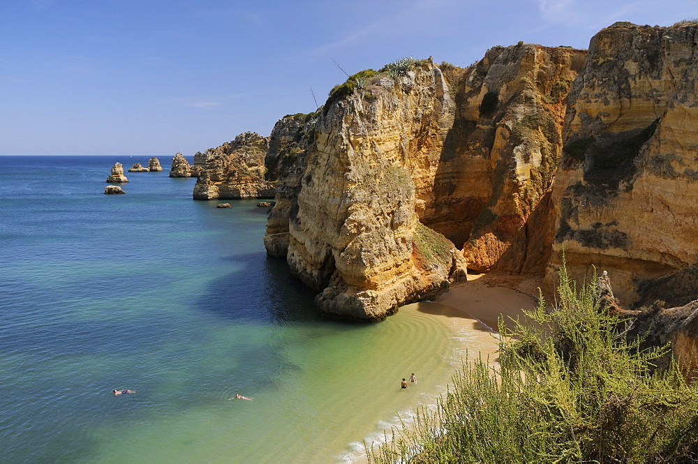 Weathered sandstone cliffs and sea stacks at Praia Dona Ana, Lagos, Algarve, Portugal, Europe