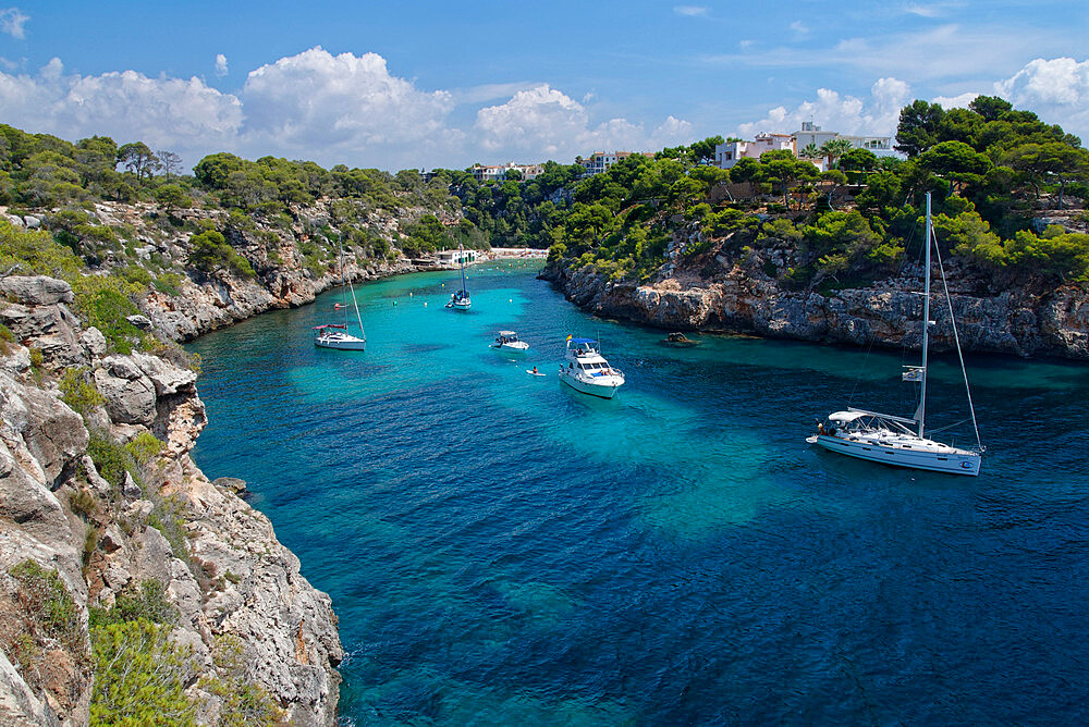 Yachts moored in the cove at Cala Pi, viewed from narrow cliff top coast path, South coast of Mallorca, Balearic Islands, Spain, Mediterranean, Europe