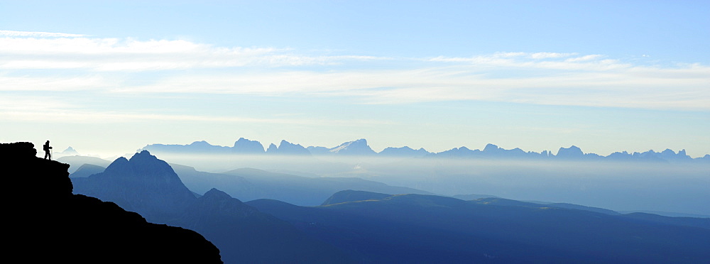 silhouette of hiker in front of panorama Dolomites with Iffinger Spitze, Piz Boe, Langkofel, Plattkofel, Marmolada, Kesselkogel, Rosengartenspitze and Palagruppe, Spronser Joch, Texelgruppe range, South Tyrol, Italy