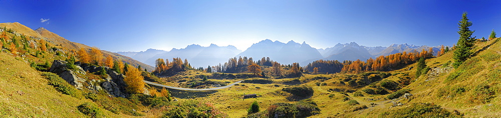 Panorama in Unterengadin with larches in autumn colours and range of Unterengadiner Dolomiten with Piz Lischana, Piz Pisoc, Piz Zuort, Piz Plavna, Piz Nuna and Piz Macun, Unterengadin, Engadin, Grisons, Switzerland