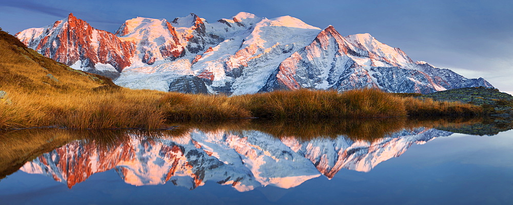 Alpen glow at the Mont Blanc Massif and its reflection in a mountain lake not far from the summit of Aiguillette du Brevent, Chamonix Valley, Haute-Savoie, France