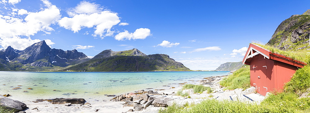 Panorama of the turquoise sea surrounded by peaks and typical house of fishermen, Strandveien, Lofoten Islands, Norway, Scandinavia, Europe