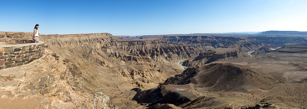 A woman looks into The Fish River Canyon in southern Namibia, Africa