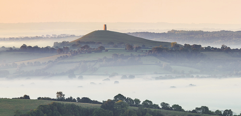 Glastonbury Tor rising above a misty landscape on an autumn morning, Somerset, England, United Kingdom, Europe