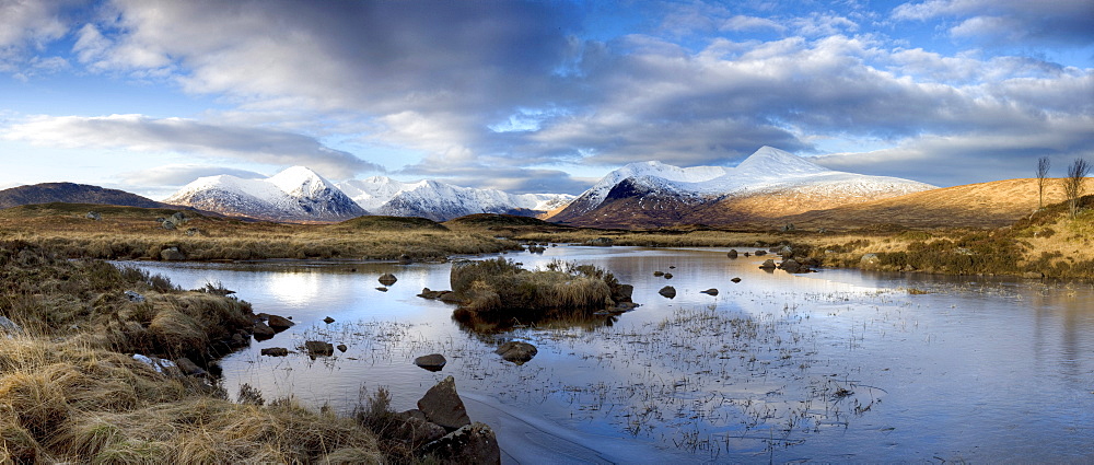 Panoramic view across Lochain Na h'Achlaise on clear winter morning towards the snow-covered mountains of the Black Mount range, Rannoch Moor, near Fort William, Highland, Scotland, United Kingdom, Europe