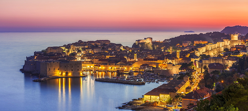 Aerial panorama of Dubrovnik Old Town at night with orange sunset sky, UNESCO World Heritage Site, Dubrovnik, Dalmatian Coast, Croatia, Europe