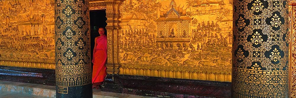 Monk in prayer hall at Wat Mai Buddhist Monastery, Luang Prabang, Laos