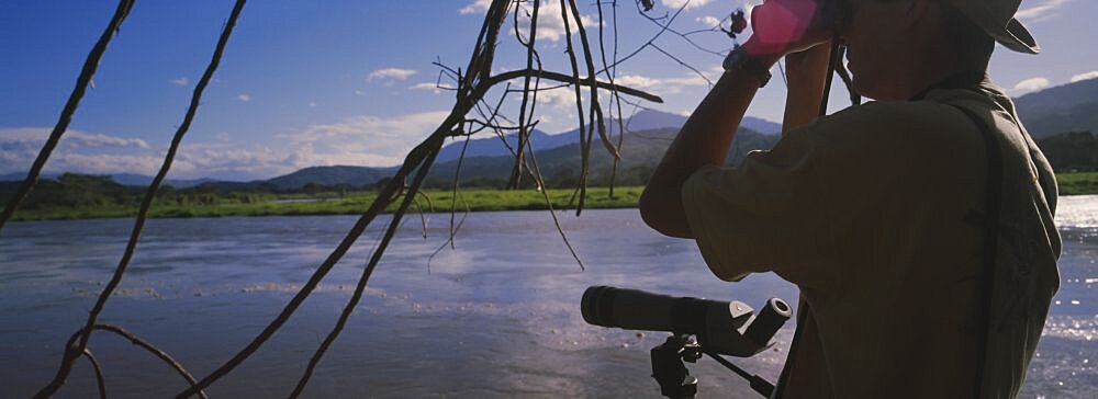 Side profile of a man looking through binoculars, Costa Rica, USA