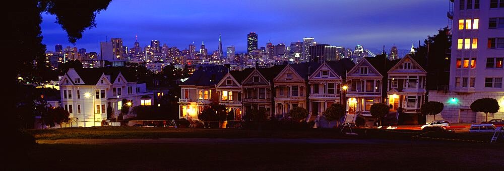 Buildings lit up dusk, Alamo Square, San Francisco, California, USA