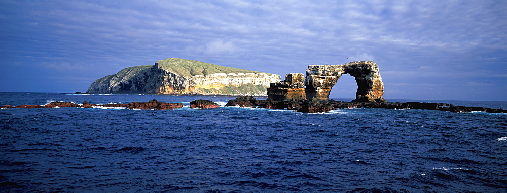 Spectacular sea arch off the volcanic cliffs of Darwin Island one of the newest and most northerly of the Galapagos Islands, Ecuador