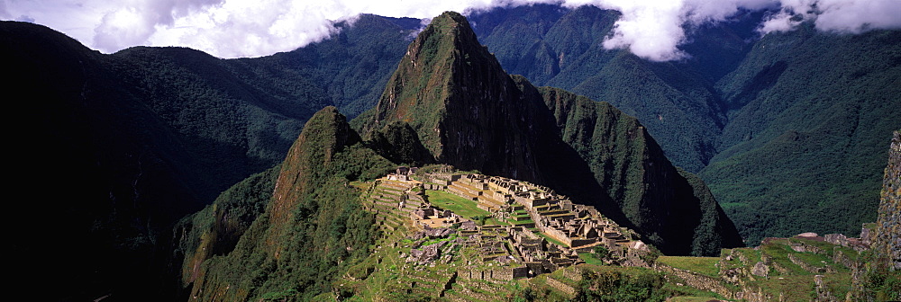 Machu Picchu view of the ancient city with Huayna Picchu peak above on the Rio Urubamba in the Vilcabamba Mountains, Highlands, Peru