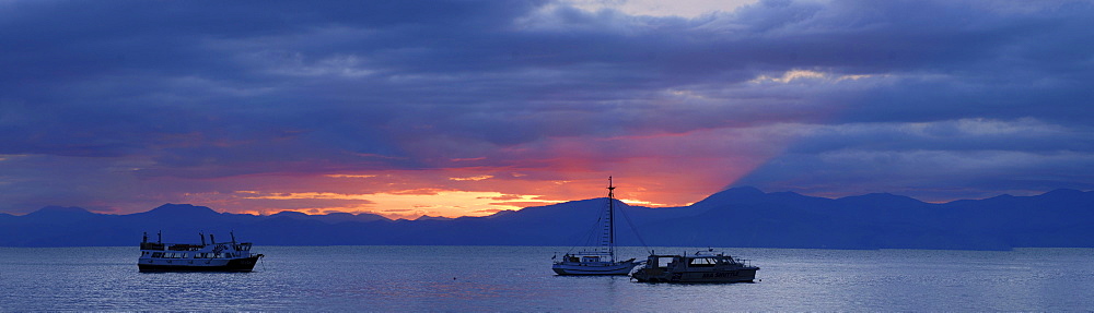 Sunrise behind boats at Kaiteriteri Beach, New Zealand