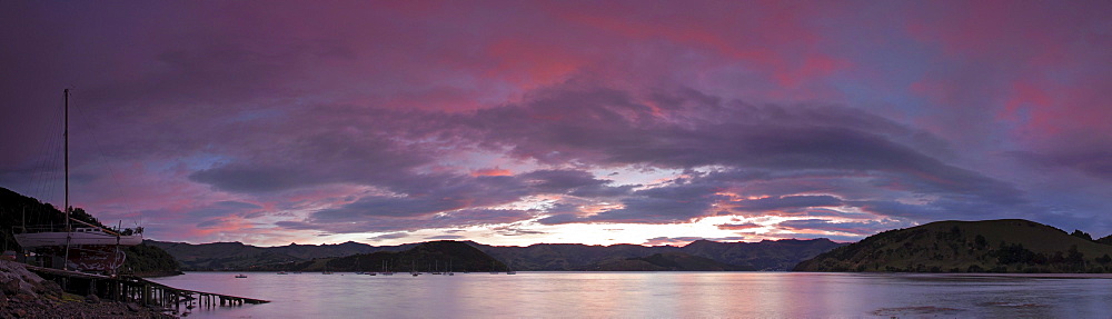 A colorful sunrise over Akaroa Harbor at the Banks Peninsula, New Zealand