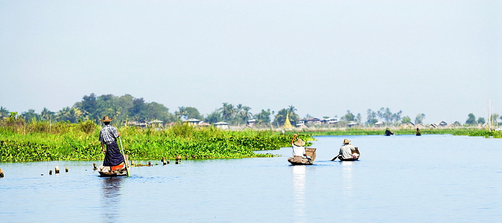 Three Burmese on boats on the Inle Lake, Myanmar, Burma, South East Asia