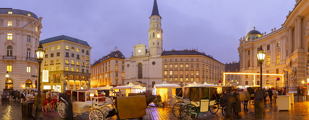 Christmas Market stalls and St. Michael Catholic Church in Michaelerplatz, Vienna, Austria, Europe