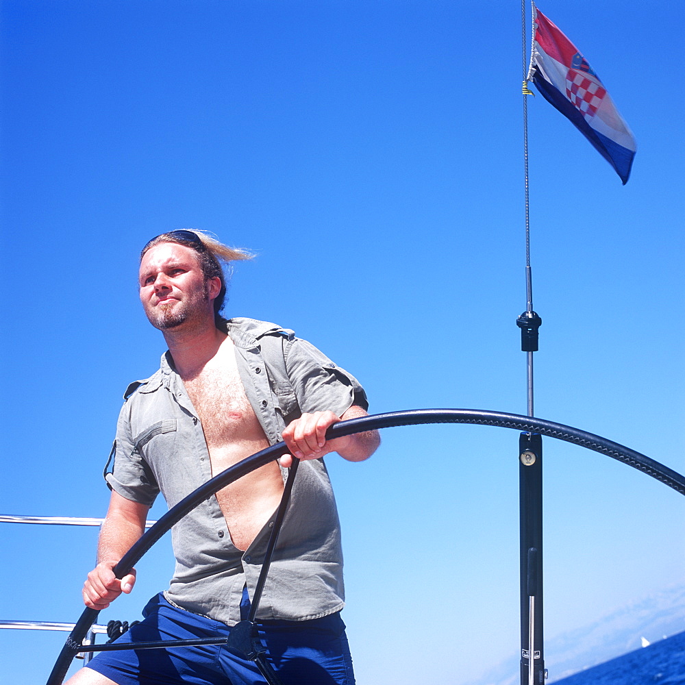 Man at sailboat's wheel, Adriatic Sea, Dalmatia, Croatia