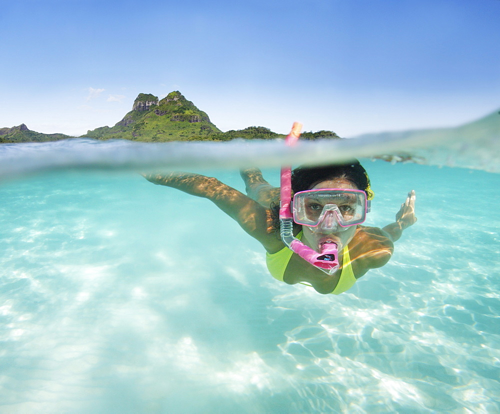 French Polynesia, Moorea, Woman free diving in turquoise ocean.