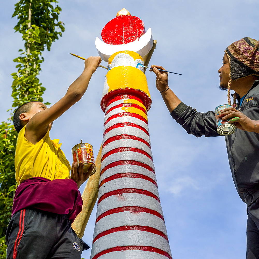 A man and boy painting a Buddhist structure, Shanku Monastery, Dentam Forest Block, Sikkim, India