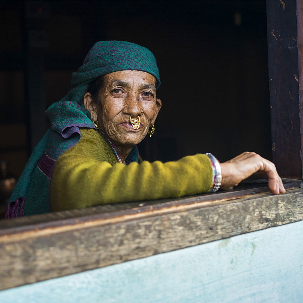 Portrait of an Indian woman looking out a window, Radhu Khandu Village, Sikkim, India