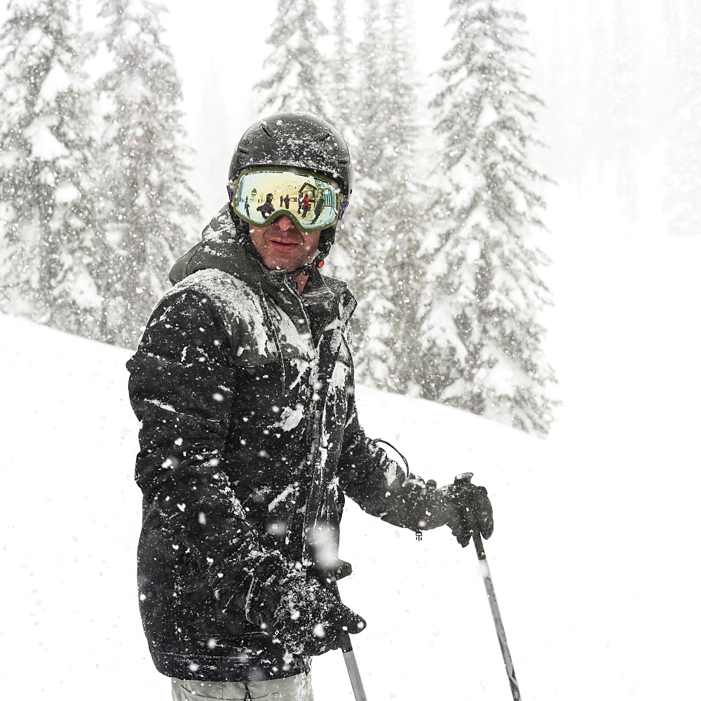 Skier standing in a heavy snowfall at Sun Peaks Resort, Kamloops, British Columbia, Canada