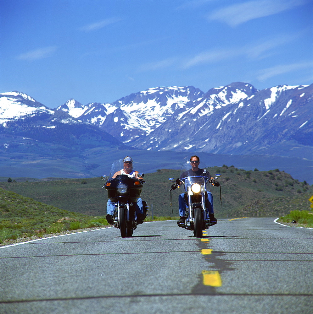 Harley Davidson bikers with snow-capped mountains in background, United States of America, North America