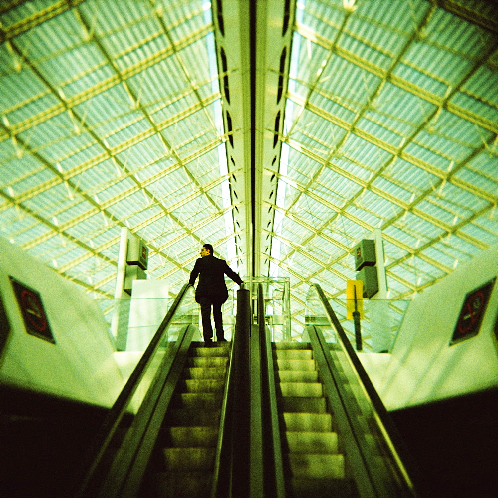 Man on escalator, Charles de Gaulle Airport, Paris, France, Europe