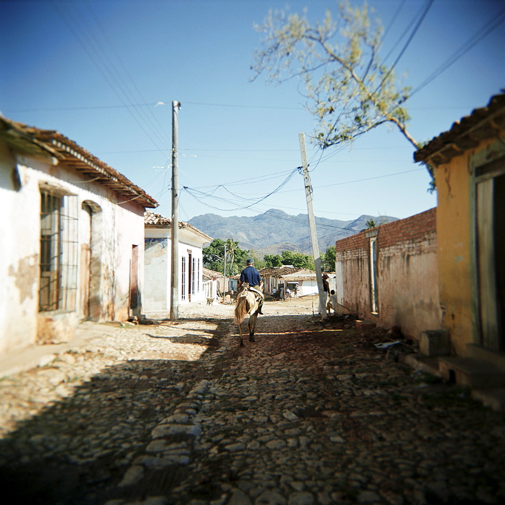 Street scene with man on horseback, Trinidad, Cuba, West Indies, Central America