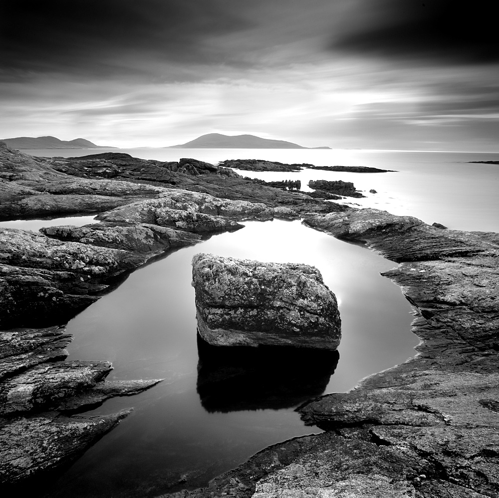 Erratic in tidal pool on isle of Taransay, looking towards Toe Head on South Harris, Outer Hebrides, Scotland, United Kingdom, Europe