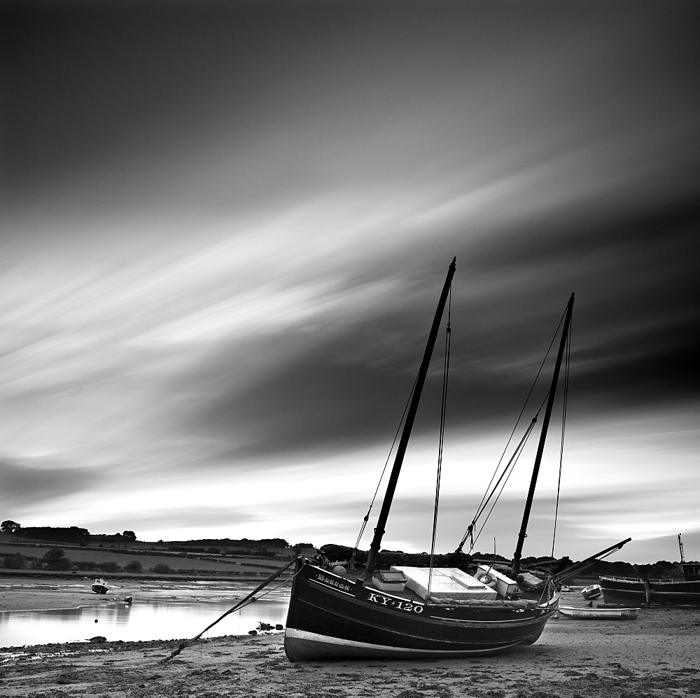 Long exposure used to record moving clouds above old wooden ketch on Aln Estuary at low tide, Alnmouth, Alnwick, Northumberland, England, United Kingdom, Europe