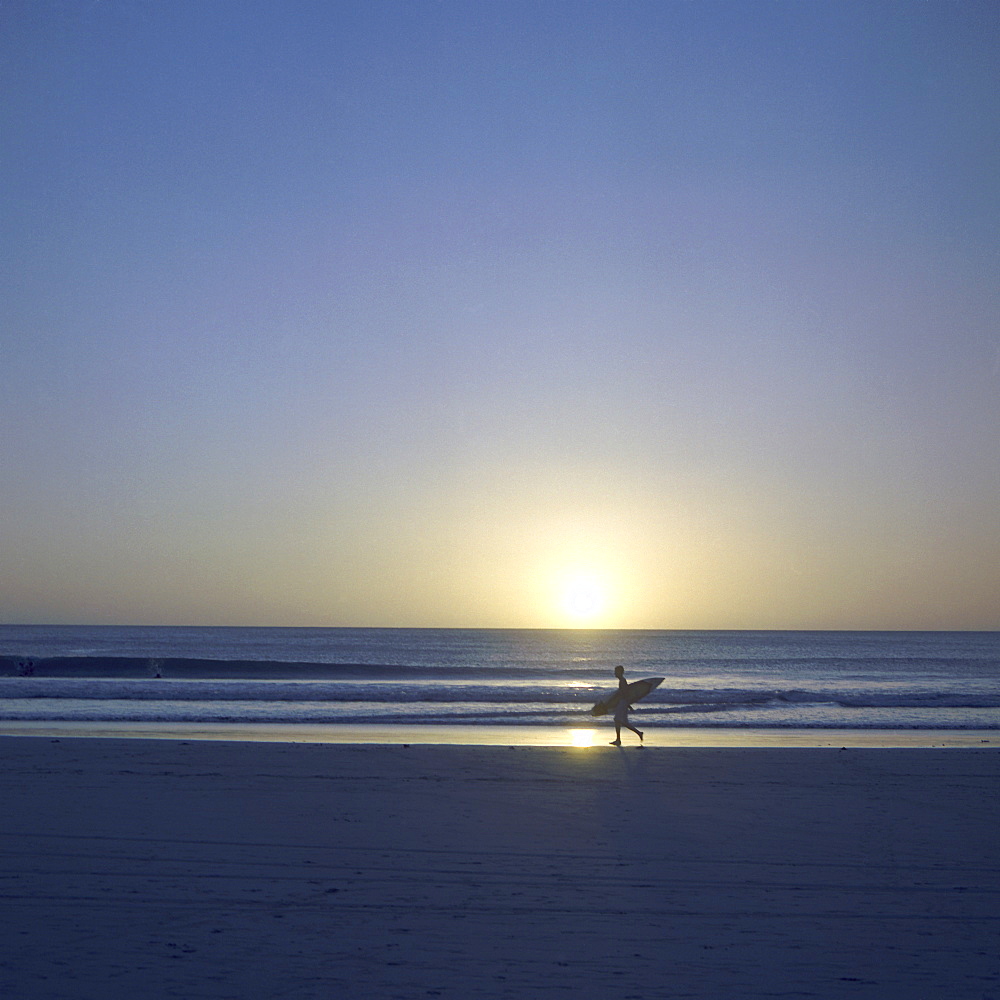 Silhouette of surfer walking on Avellanas Beach, Nicoya Peninsula, Costa Rica, Central America