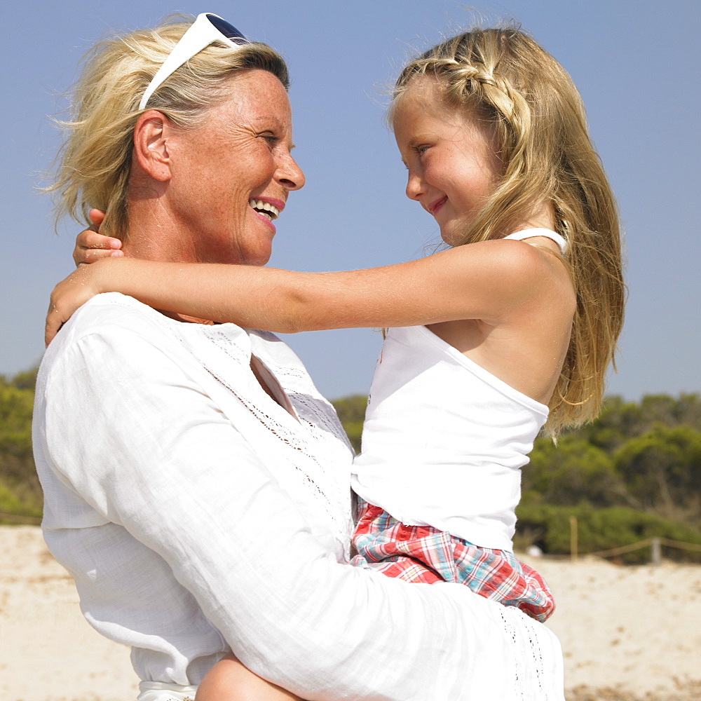 Grandmother and grandaughter (6-8) on beach