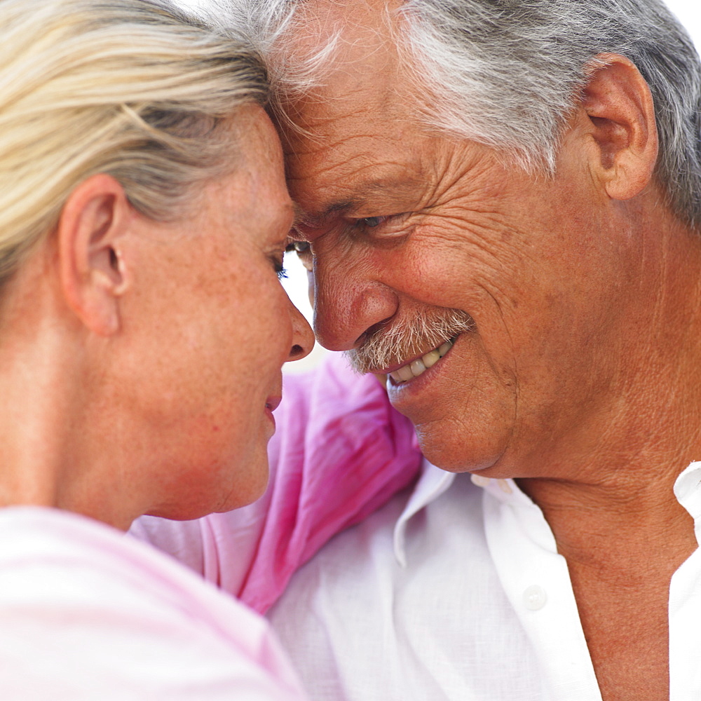 senior couple embracing outdoors, close-up