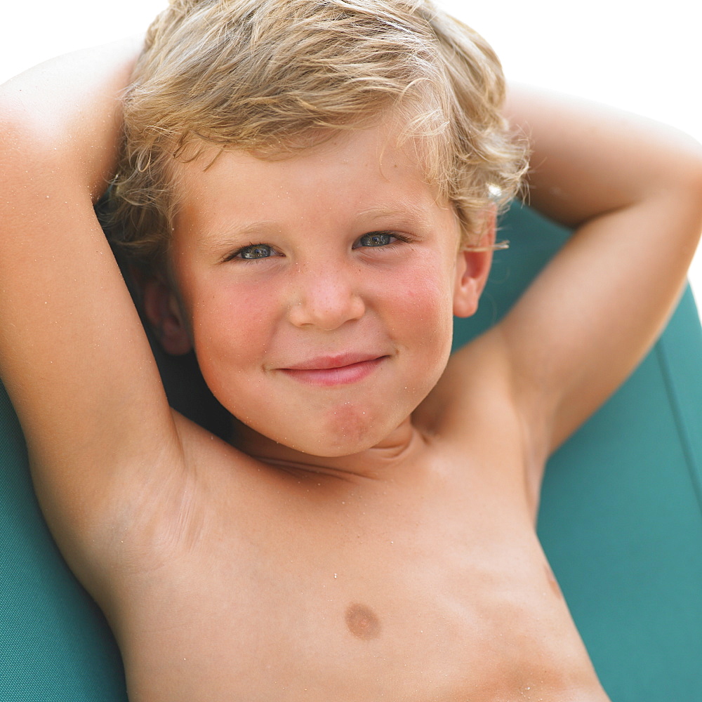 Boy (6-8) on sunlounger