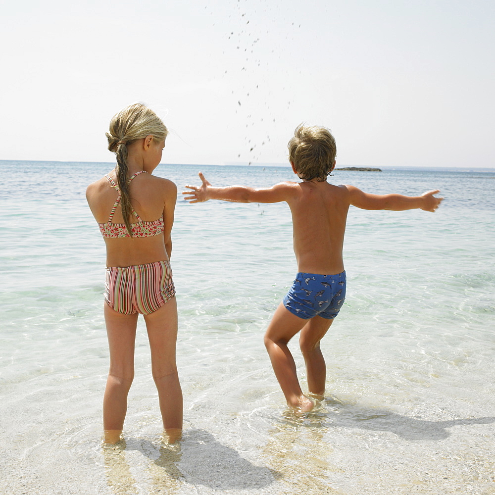 Boy and girl on beach playing in the water