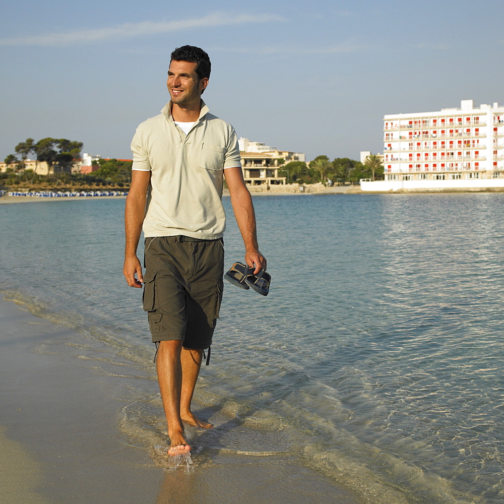 Man walking along seashore