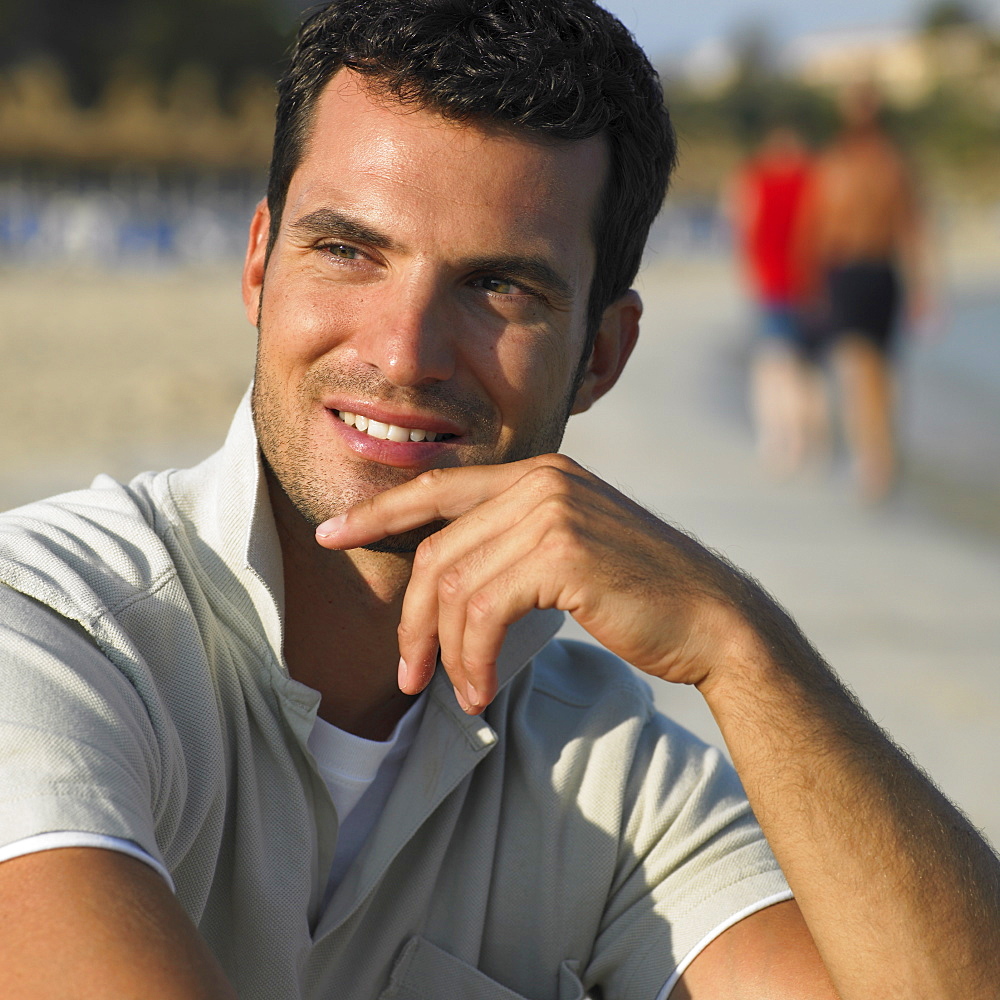 Man sitting on beach, close-up