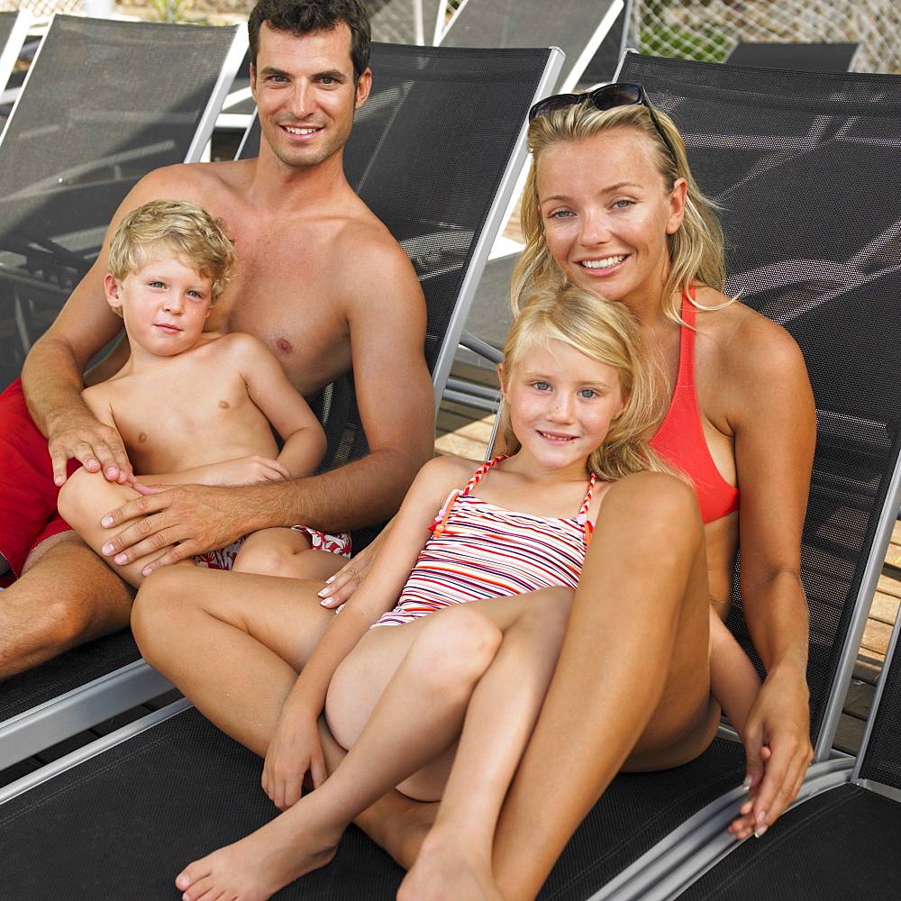 Family relaxing on sunloungers, children (6-8)