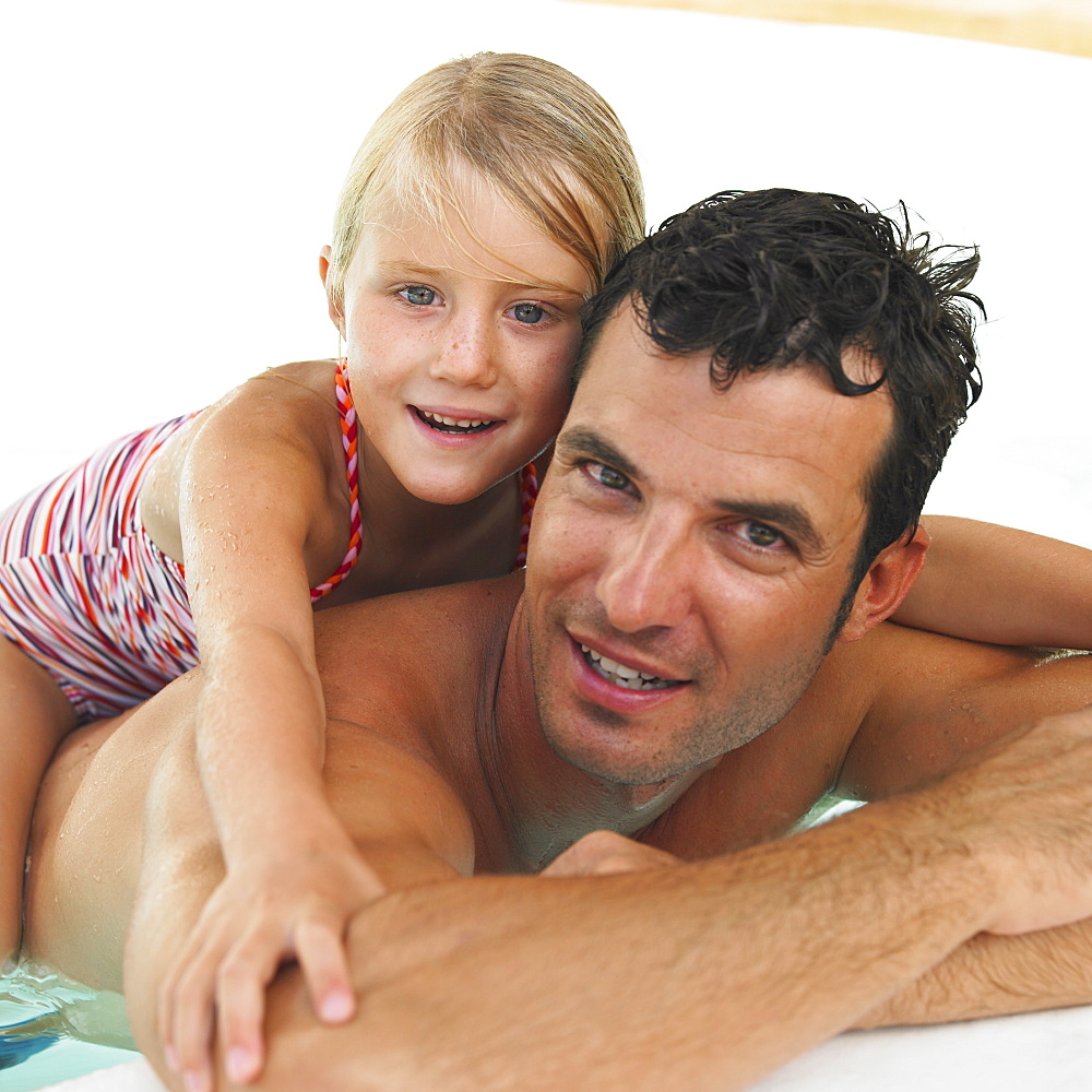 Father and daughter (6-8) in swimming pool